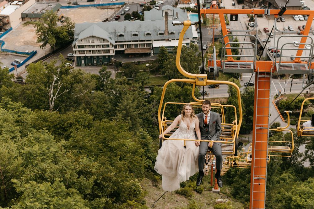 Bride and groom riding yellow ski chairlift above Gatlinburg Tennessee on wedding day.