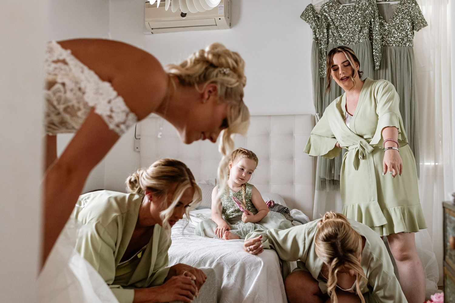A light and airy bedroom scene with people gathered around a bed while a golden retriever rests nearby at Quinta da Bichinha