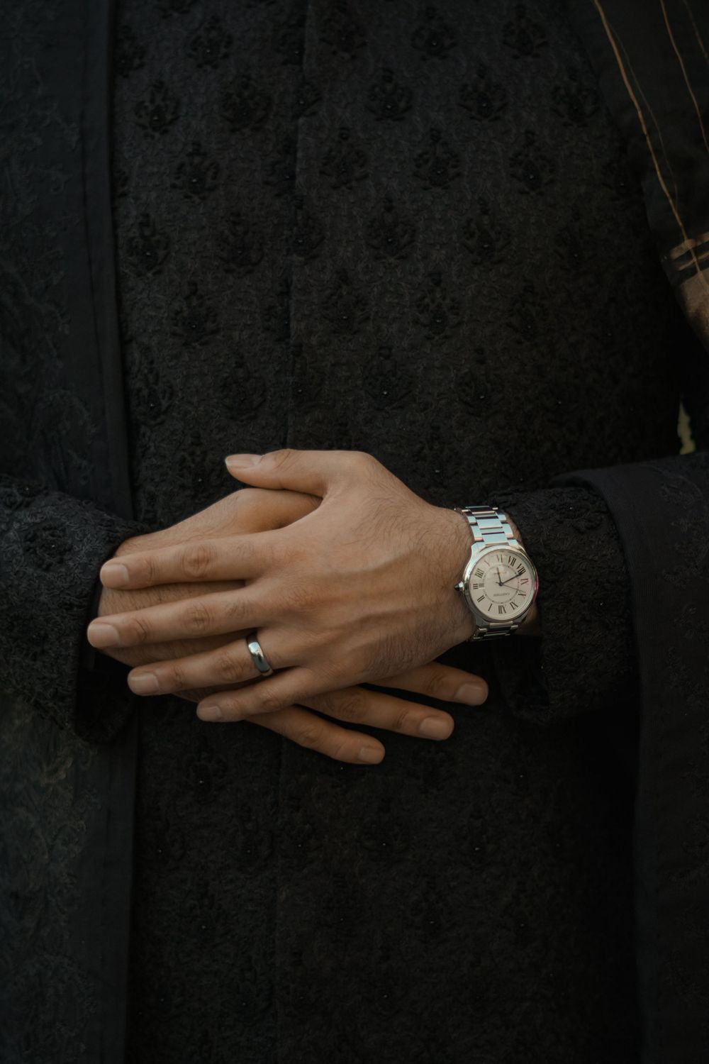 Close-up shots of hands wearing wedding rings and watches against a dark background.