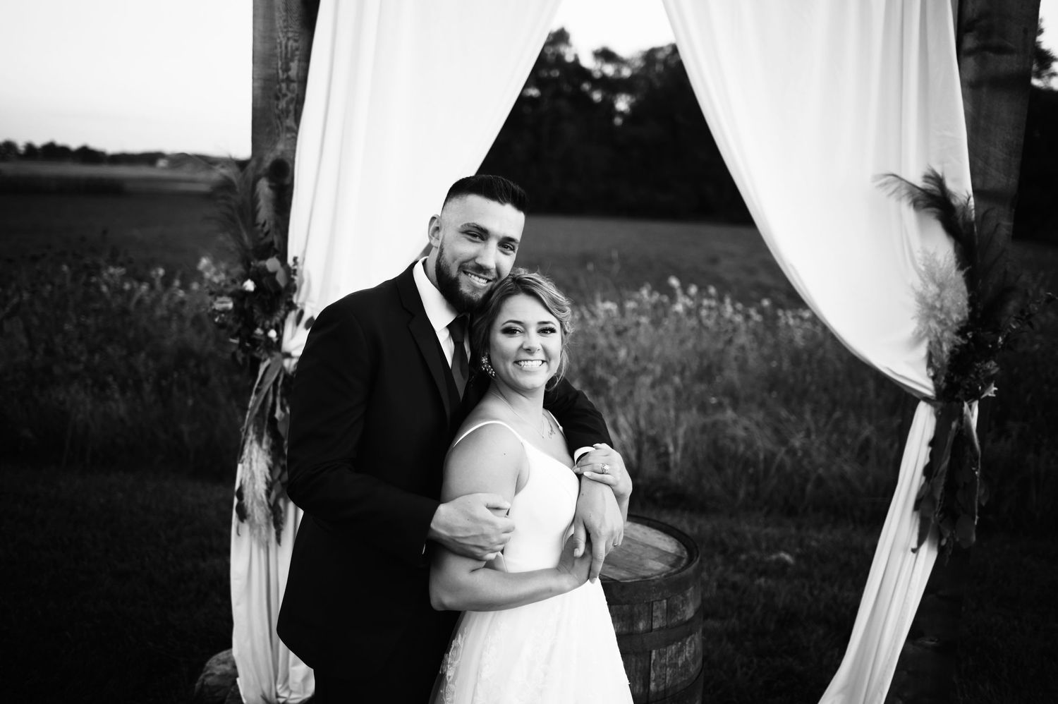 Black and white wedding photos showing intimate moments between newlyweds in an outdoor setting.