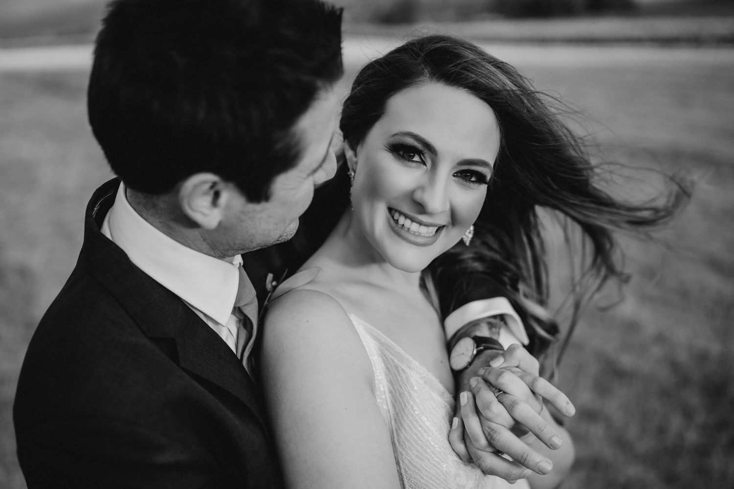 A romantic black and white portrait of a bride and groom sharing a joyful moment together.