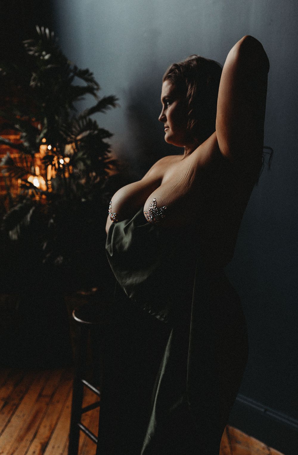 Dramatic portrait against foliage backdrop in moody lighting.