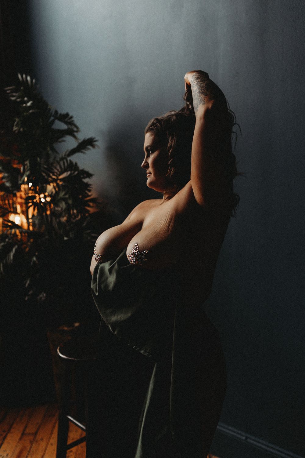 Artistic portrait with plant silhouettes and dramatic spotlighting.