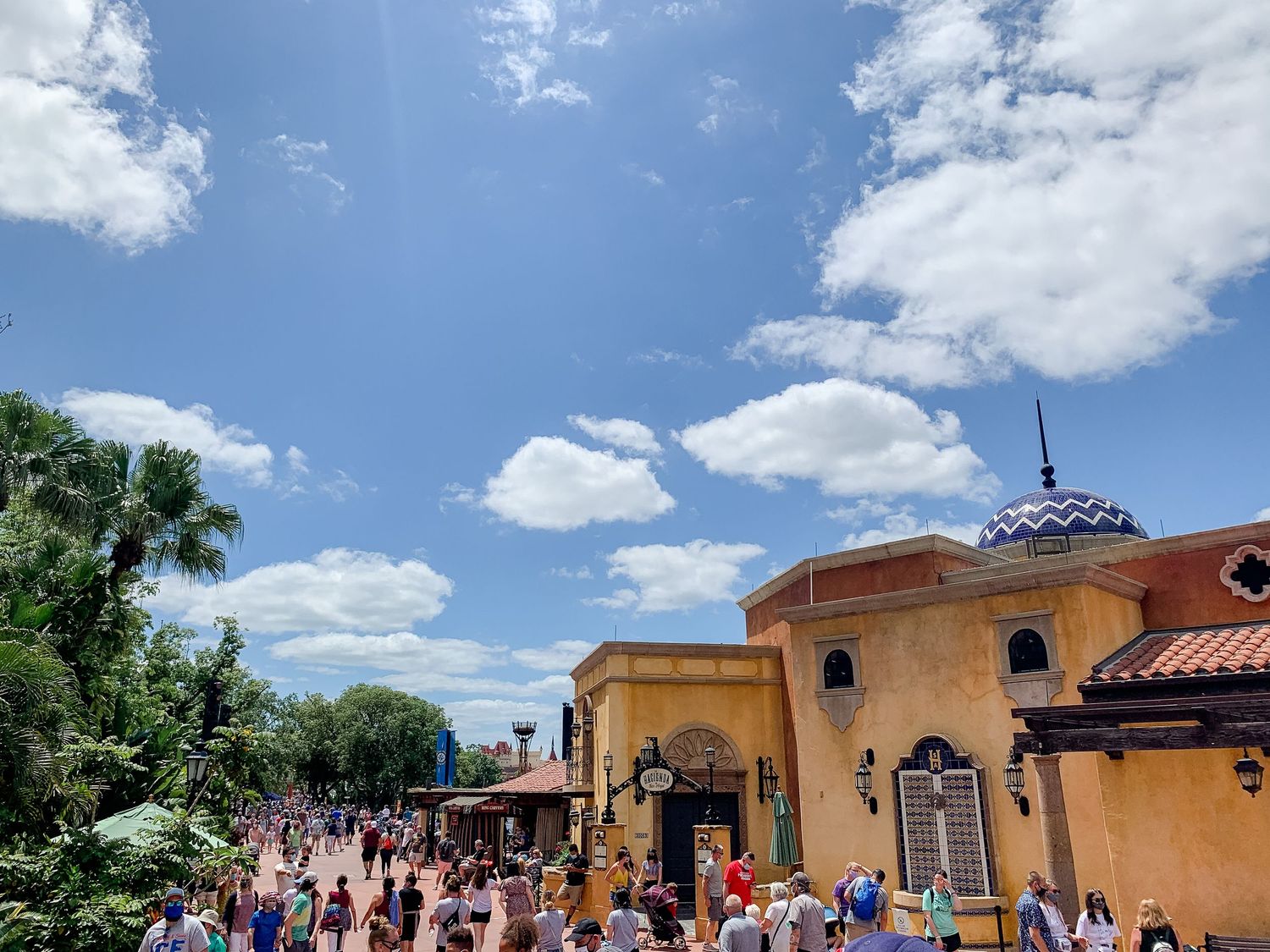 Mediterranean-style theme park buildings with terracotta roofs under bright blue skies.