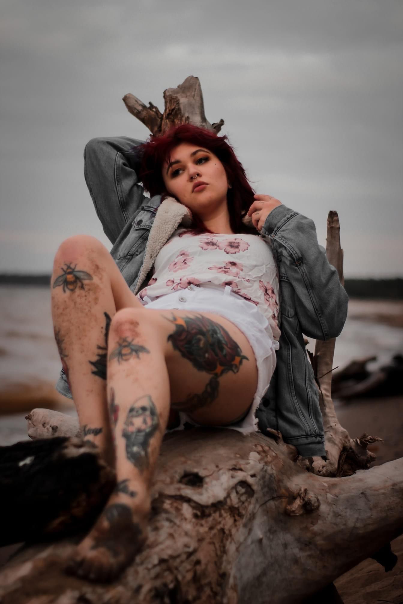 moody photo of a tattooed woman on a stormy beach