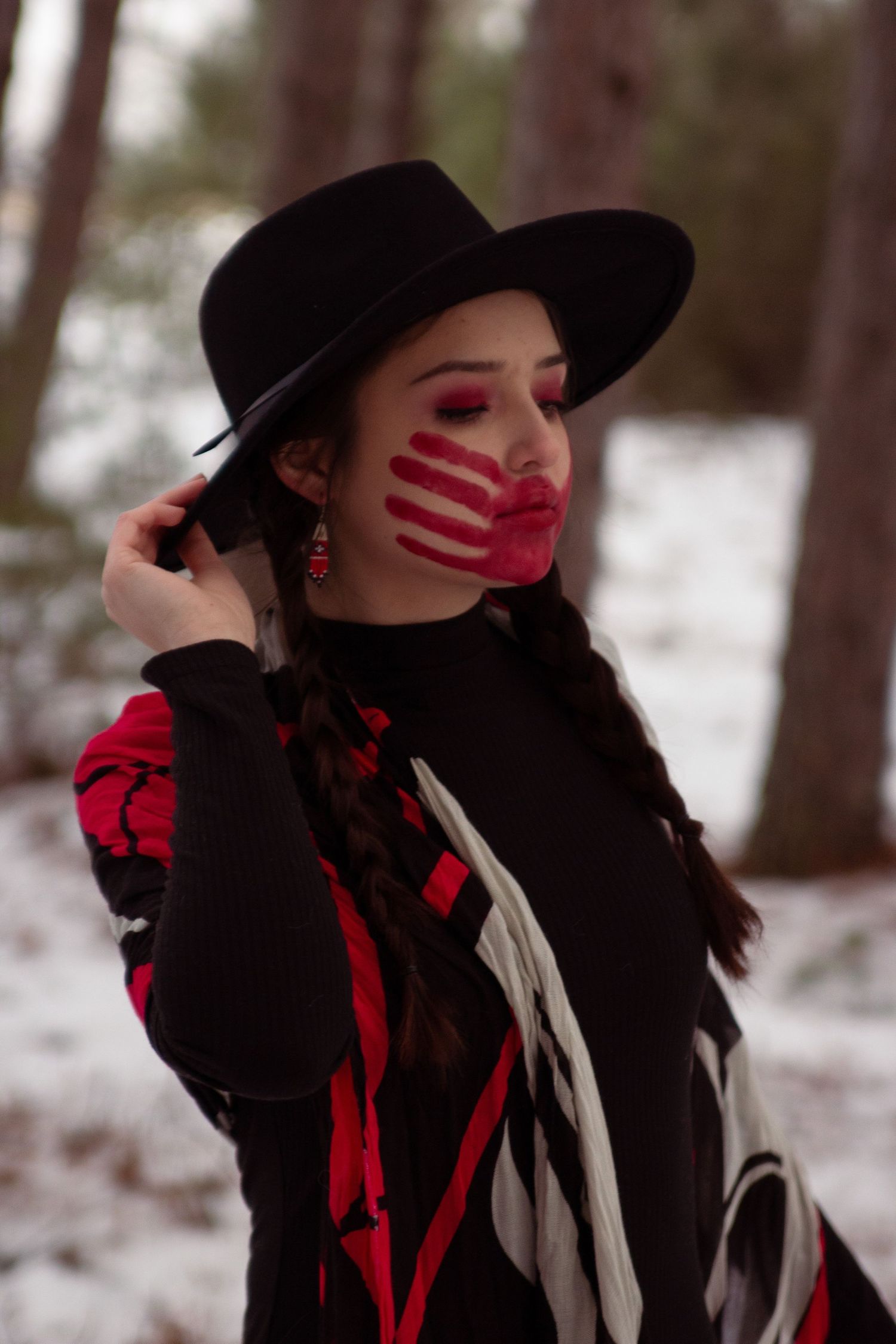 Native American woman wearing native art with No More Stolen Sisters face paint