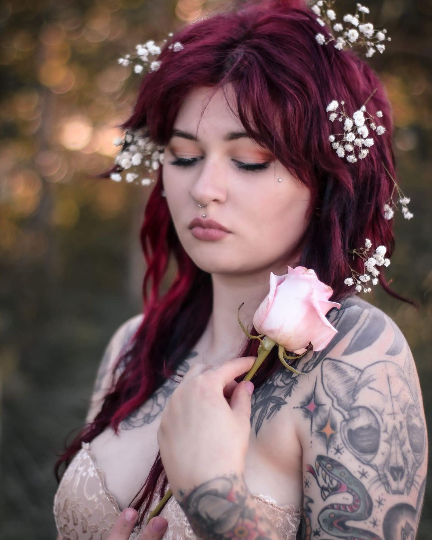 tattooed woman posing in a forest with flowers in Minnesota