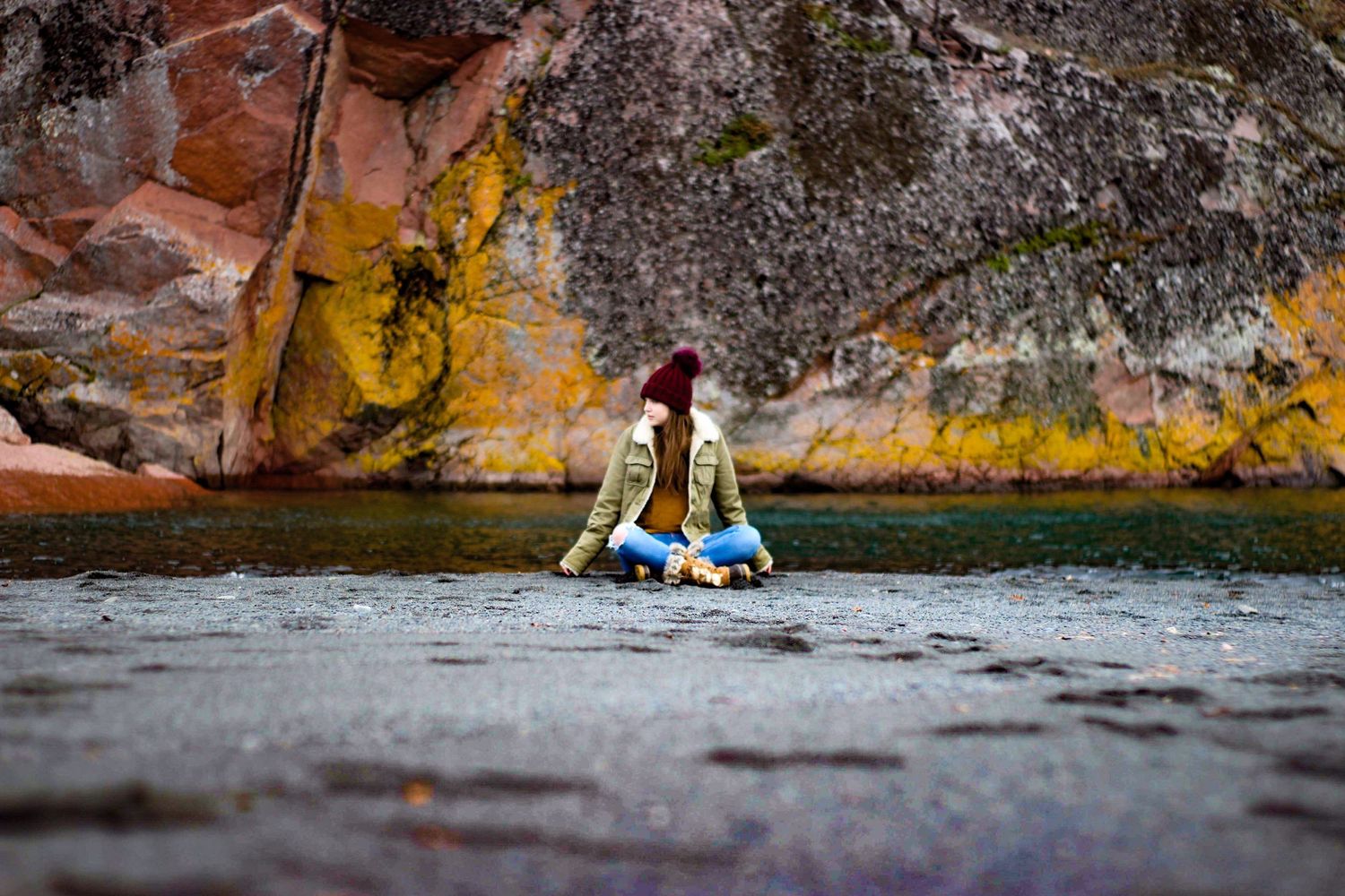 Girl posing for senior portraits on the black sand beach in Minnesota lake superior