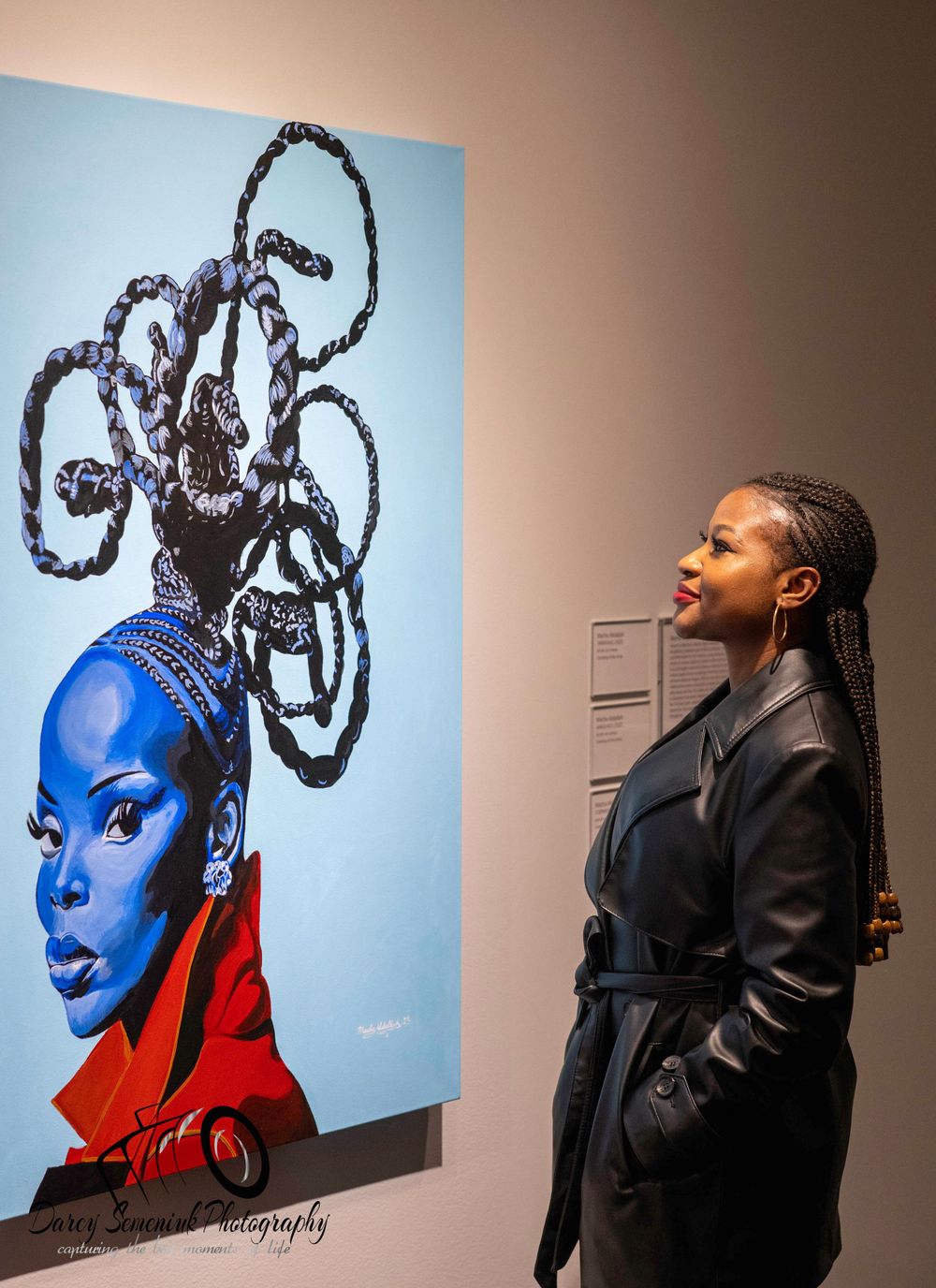 A series of art gallery photos showing a person viewing a striking blue and red portrait artwork displayed on the wall.