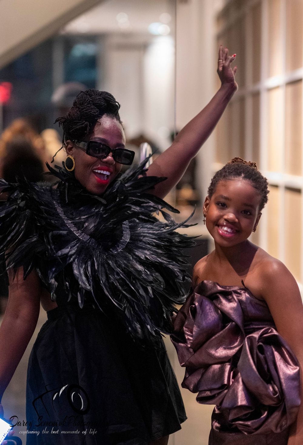 A person in a black feathered outfit and purple dress poses joyfully in a series of four connected photos.