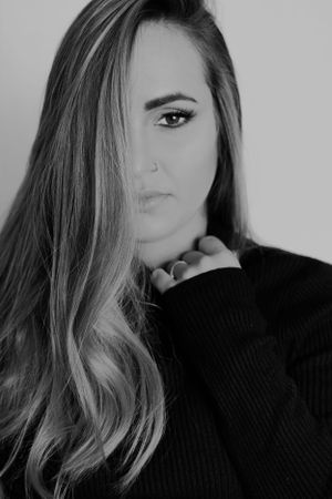 Dramatic black and white portrait of woman with long hair wearing a black turtleneck sweater.