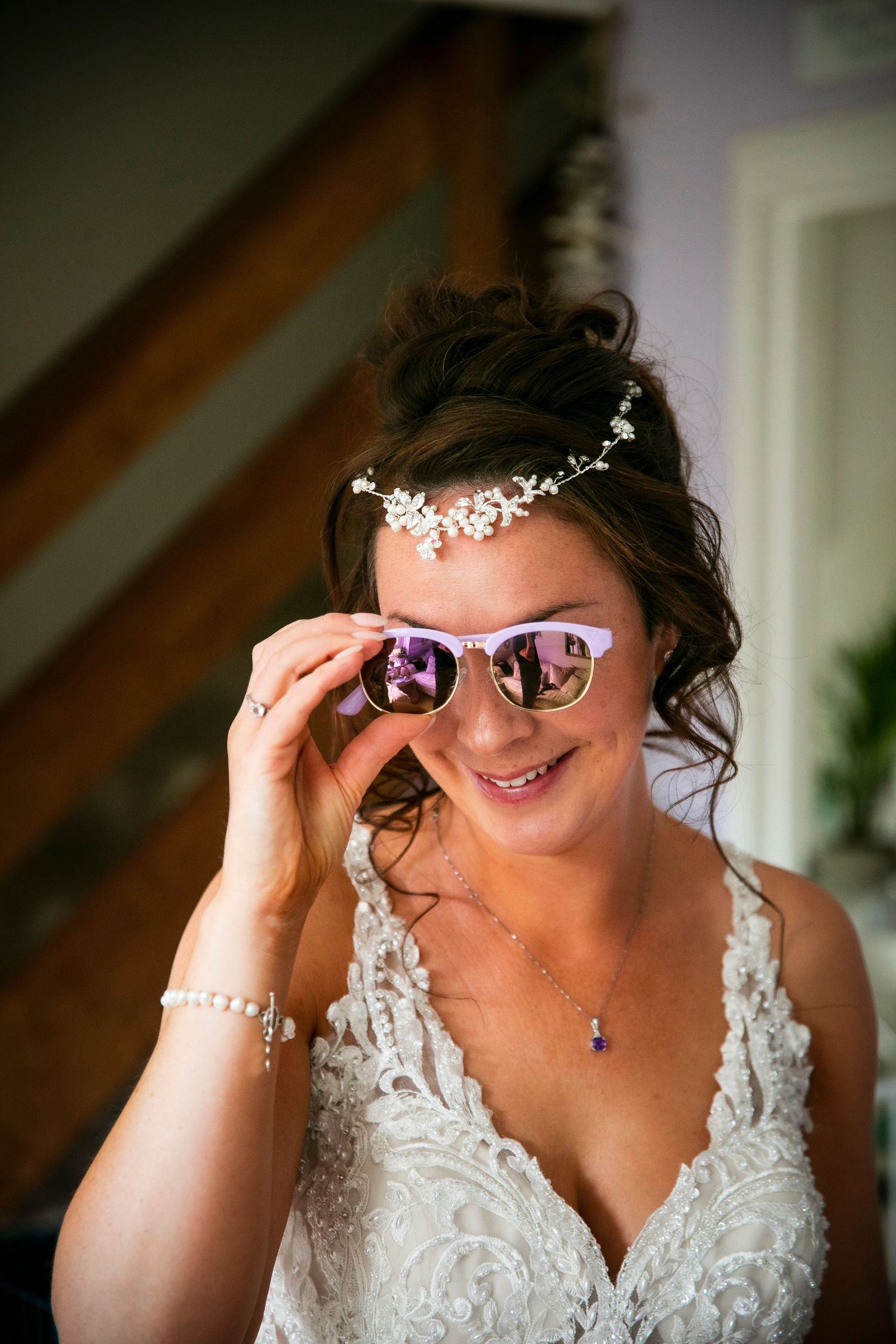 Playful sequence of bride adjusting glasses while wearing lace wedding dress.