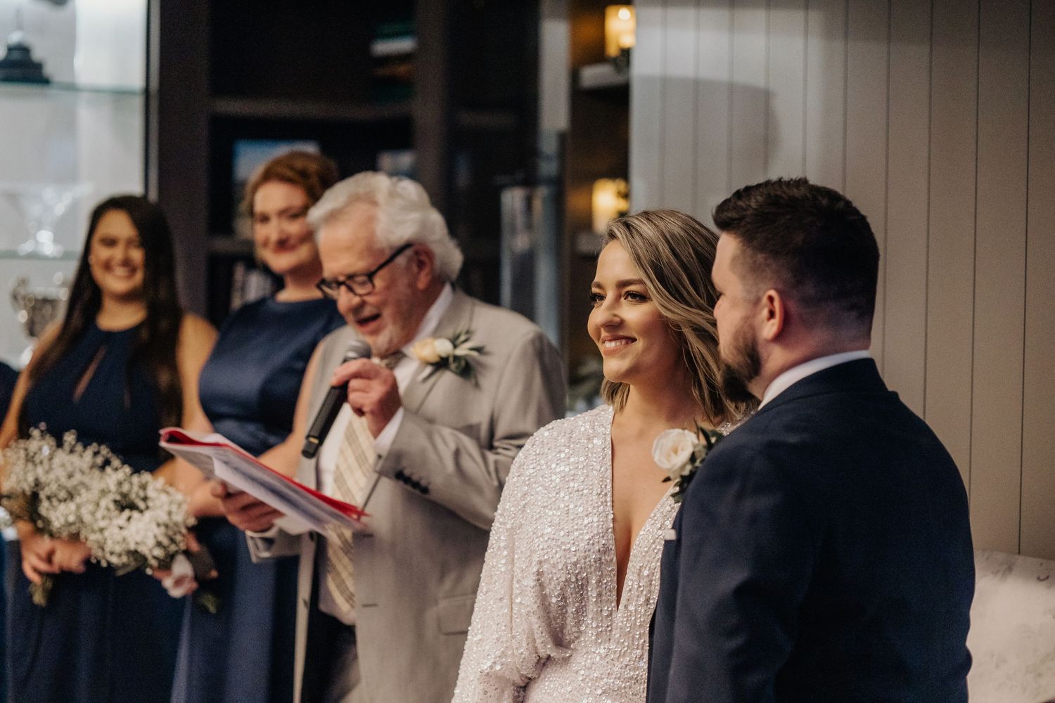 Wedding celebration with guests indoors showing joyful reactions.