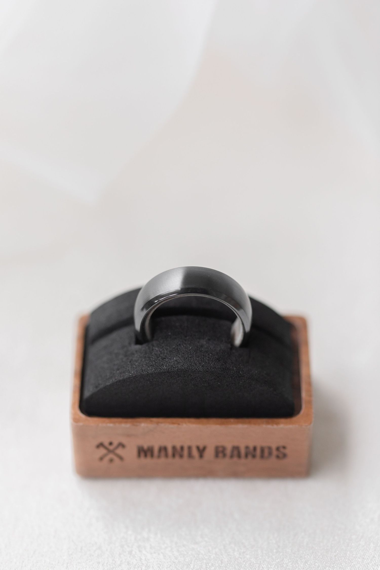 Manly Bands ring display holder in black and copper tones.
