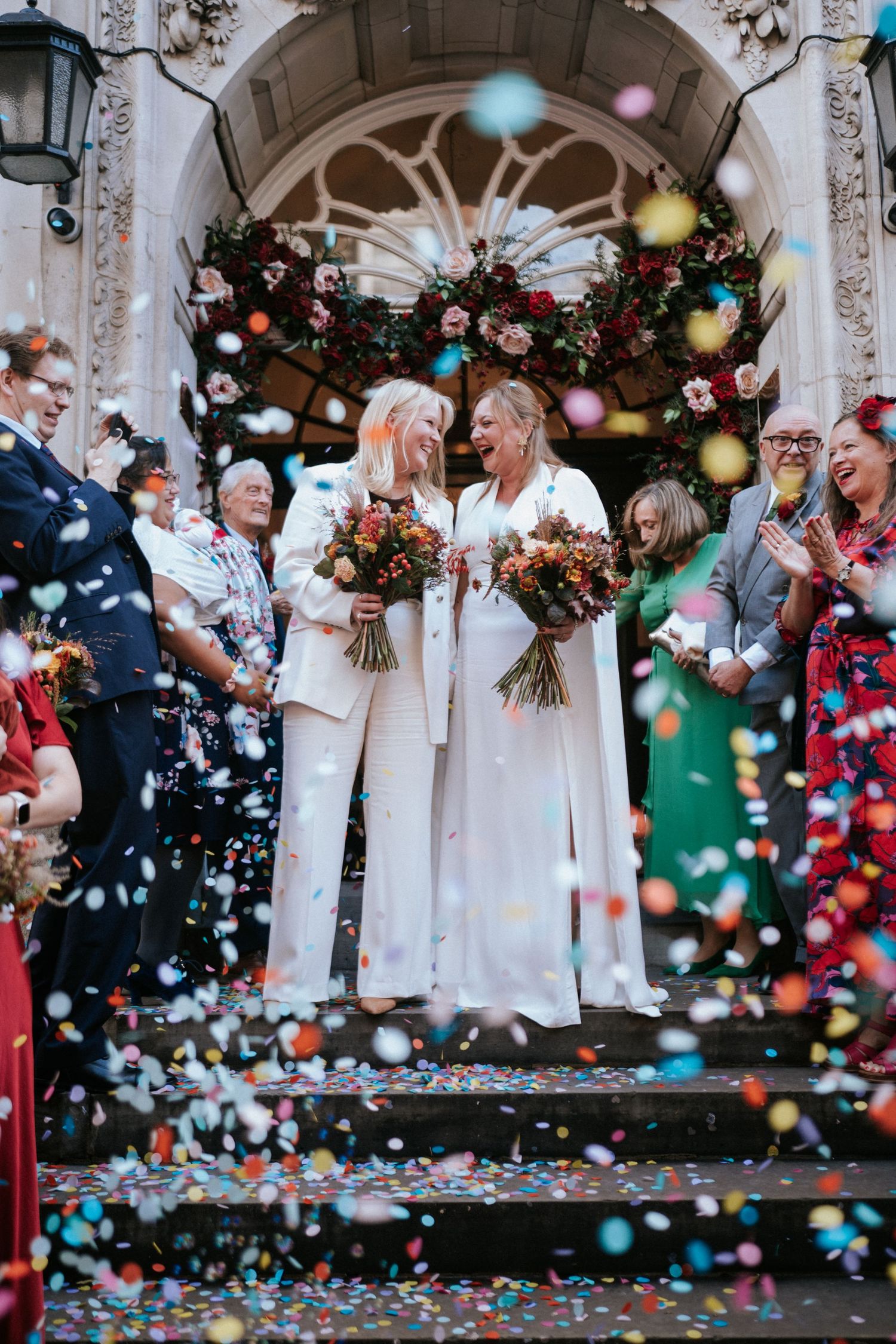 A same-sex couple standing on the steps of London Chelsea Town Hall