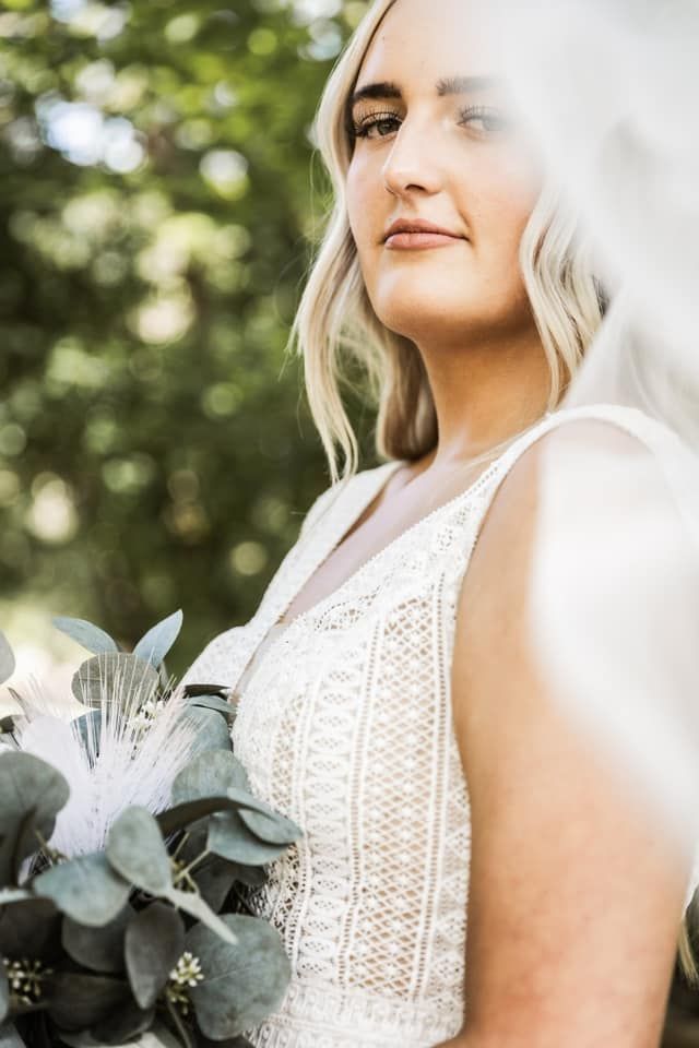 OKC bride poses showing off her beautiful dress and elegant makeup look in okc oklahoma with gaby makeup artistry