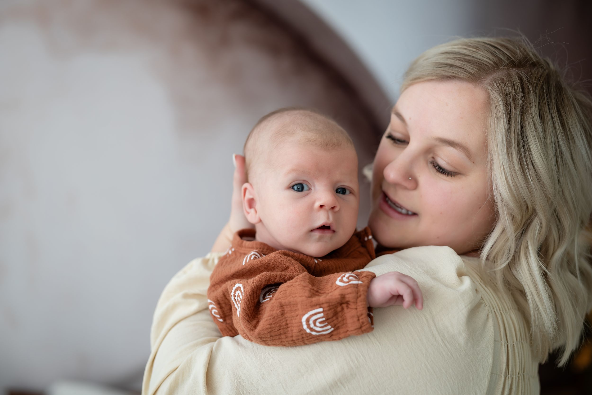 Close up of baby boys face over moms shoulder