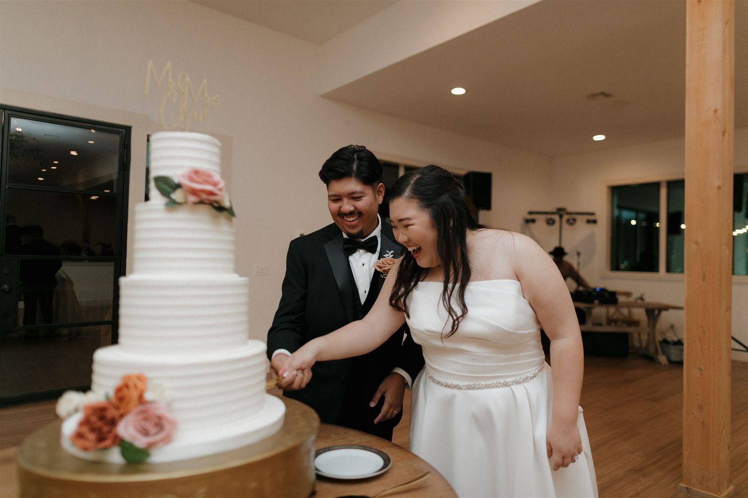 Wedding cake cutting moment with classic white tiered cake.