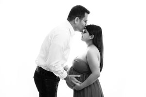 Black and white maternity photo showing tender moment between expecting couple.