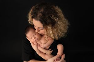 Intimate black and white studio portrait against dark background.
