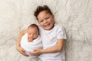 Sweet portrait of siblings on white furry backdrop.