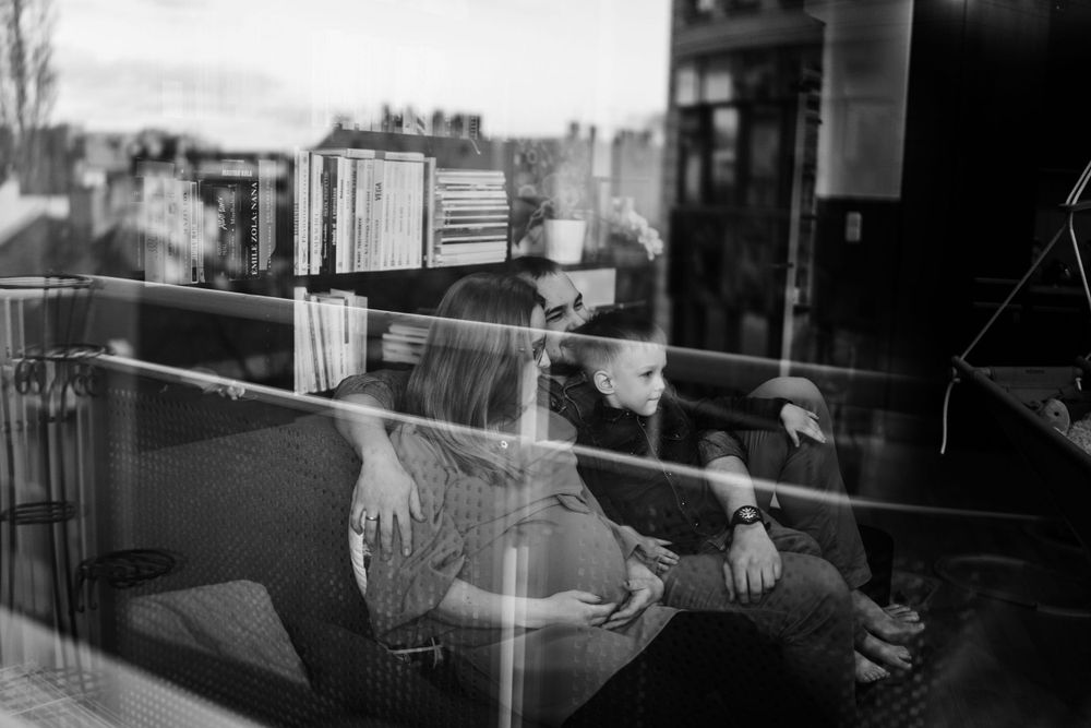 Black and white reflection in window glass showing urban scenery and furniture.