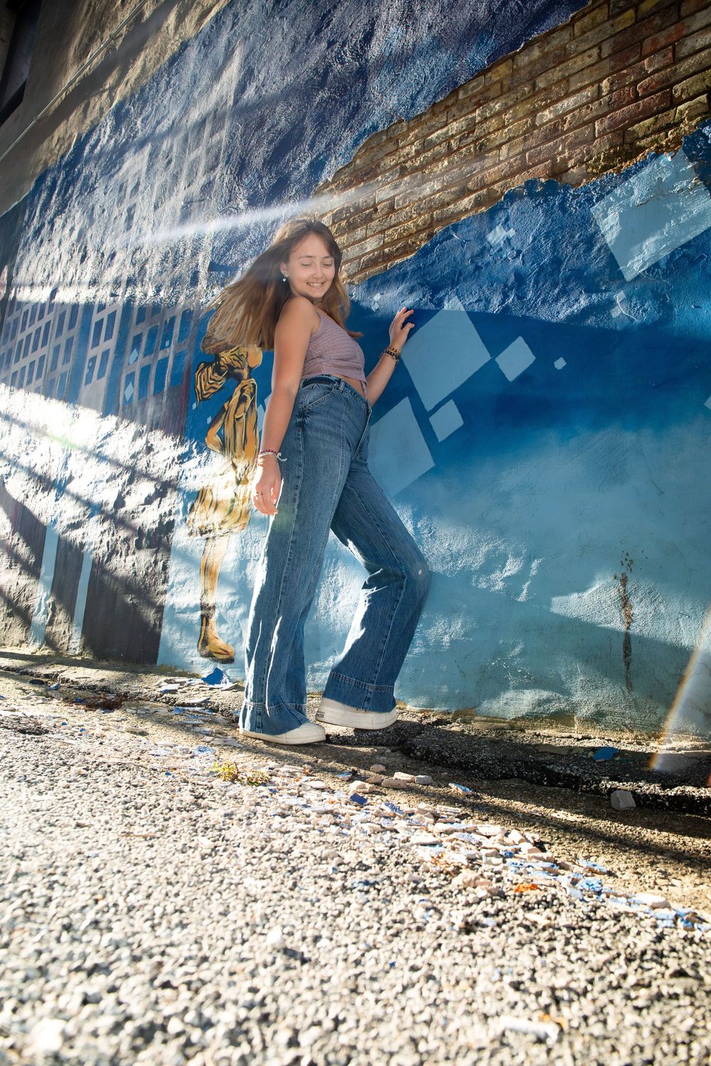 Low angle shot of person posing against blue geometric wall mural.
