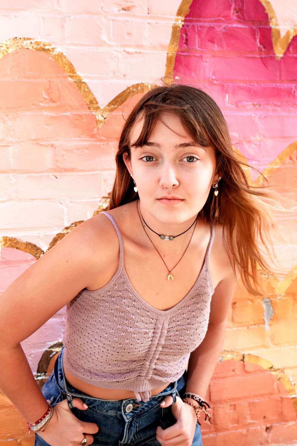 Casual summer style against pink heart mural wall.