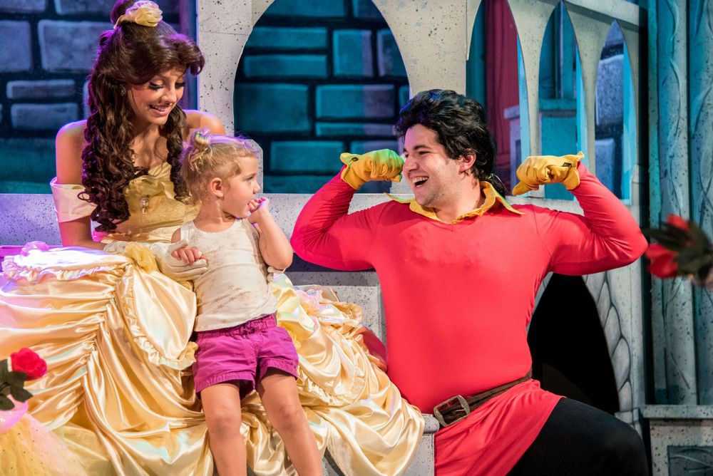 Child enjoys a playful moment with costumed performers during a live fairytale-themed event. Captured by Chris Cornish Photography.