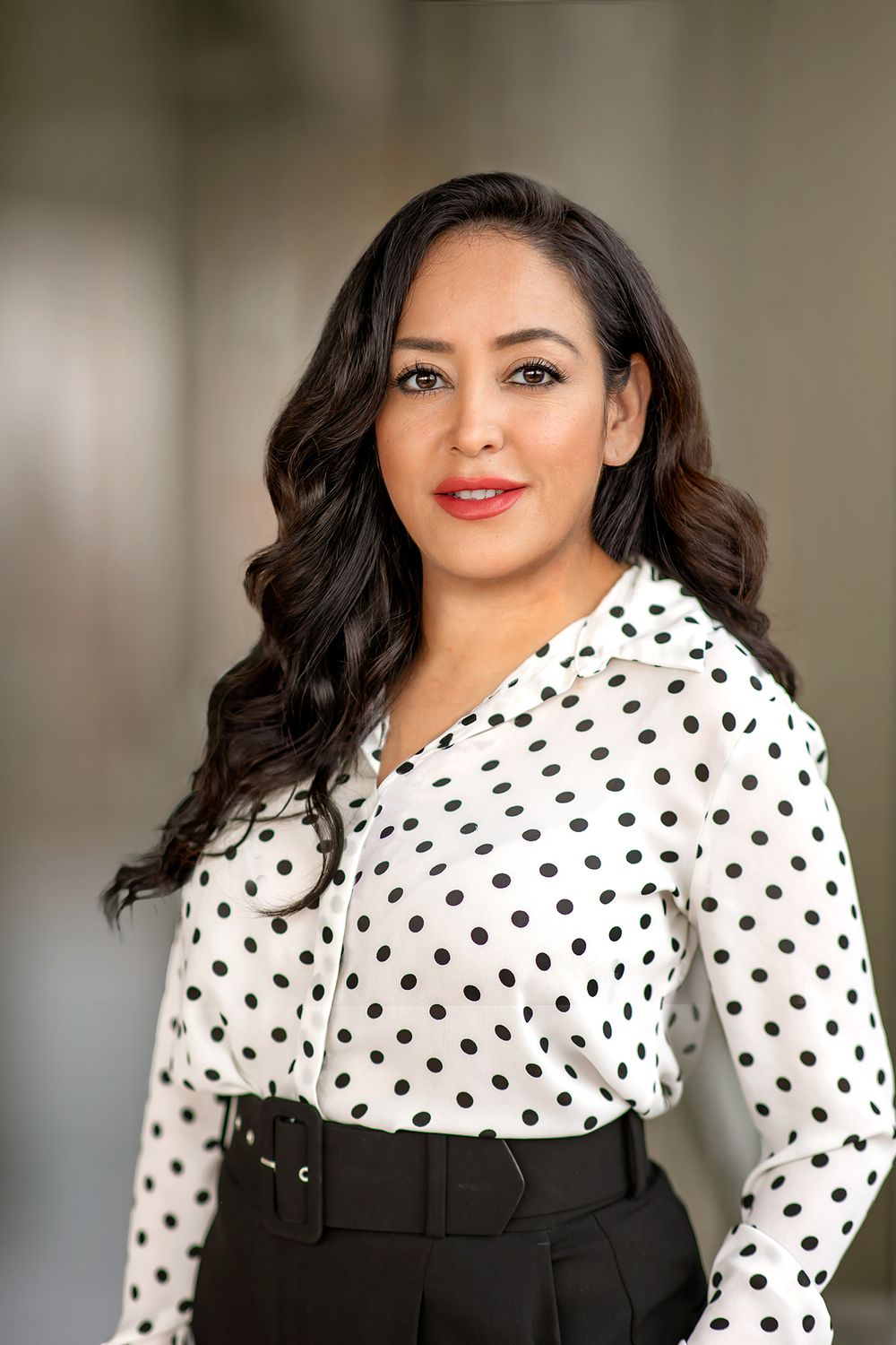 Spanish woman posing in polka dot shirt for headshot