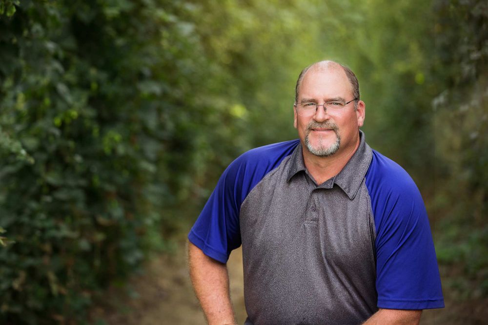 headshot of male in the hop field at harvest