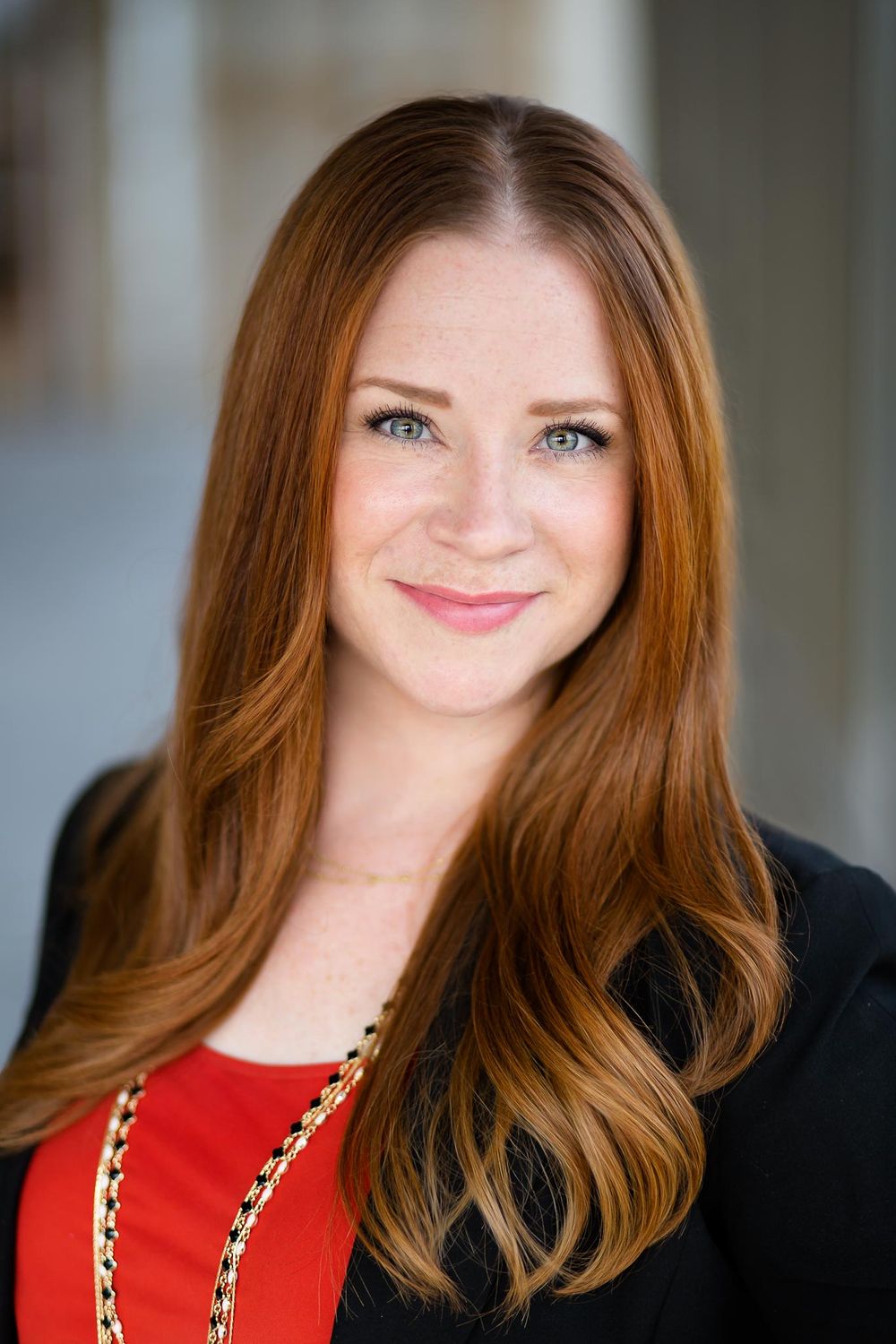 redheaded woman smiles for a business headshot