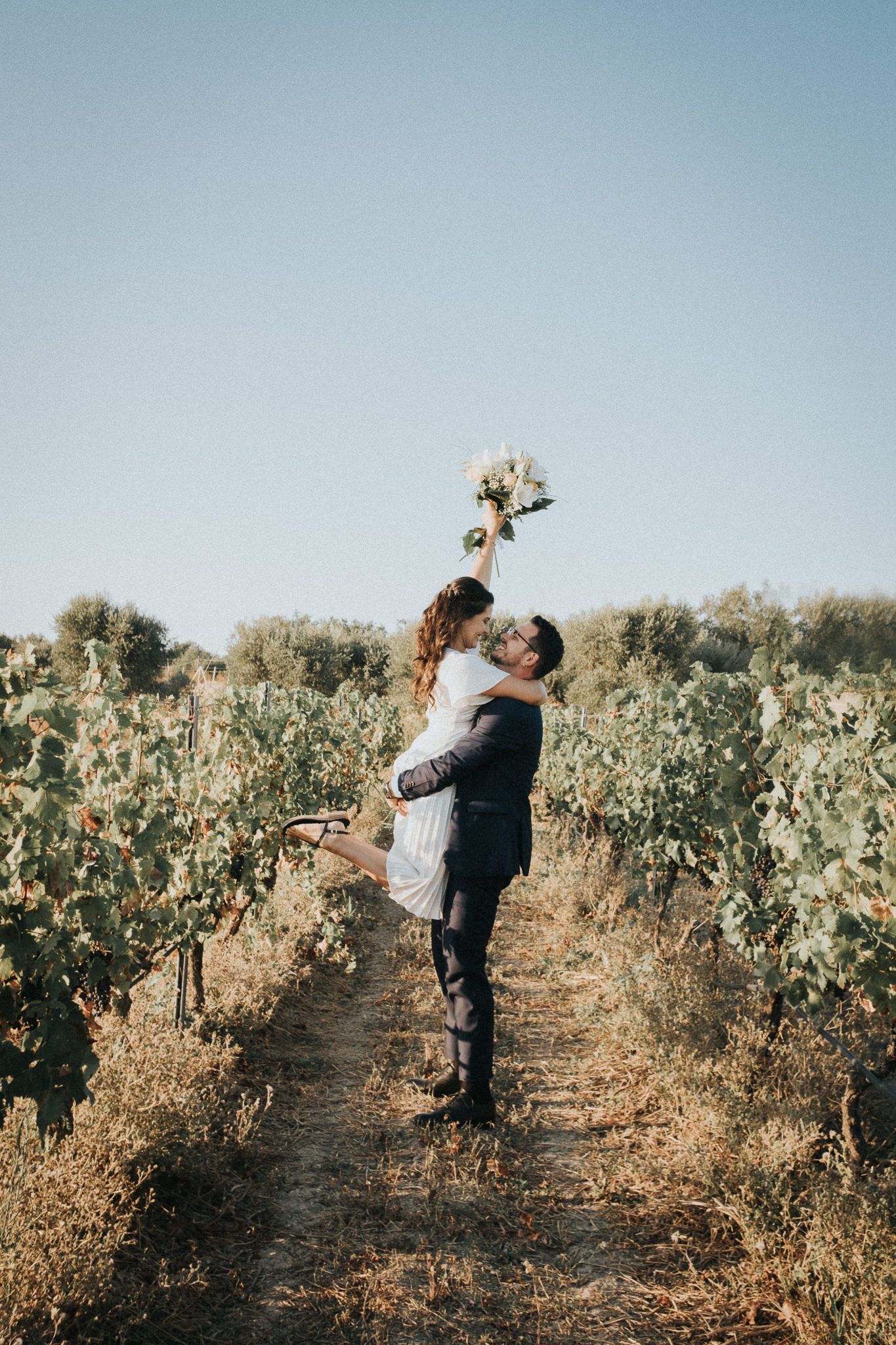 international wedding, couple holding each other in the vineyard