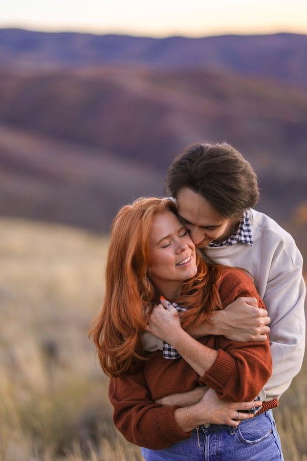 couple dancing in a field for their engagement photos.
