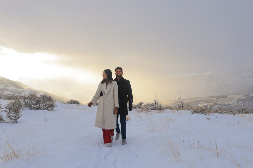 romantic proposal in Salt Lake City, couple holding flowers at sunset with snowy mountains.