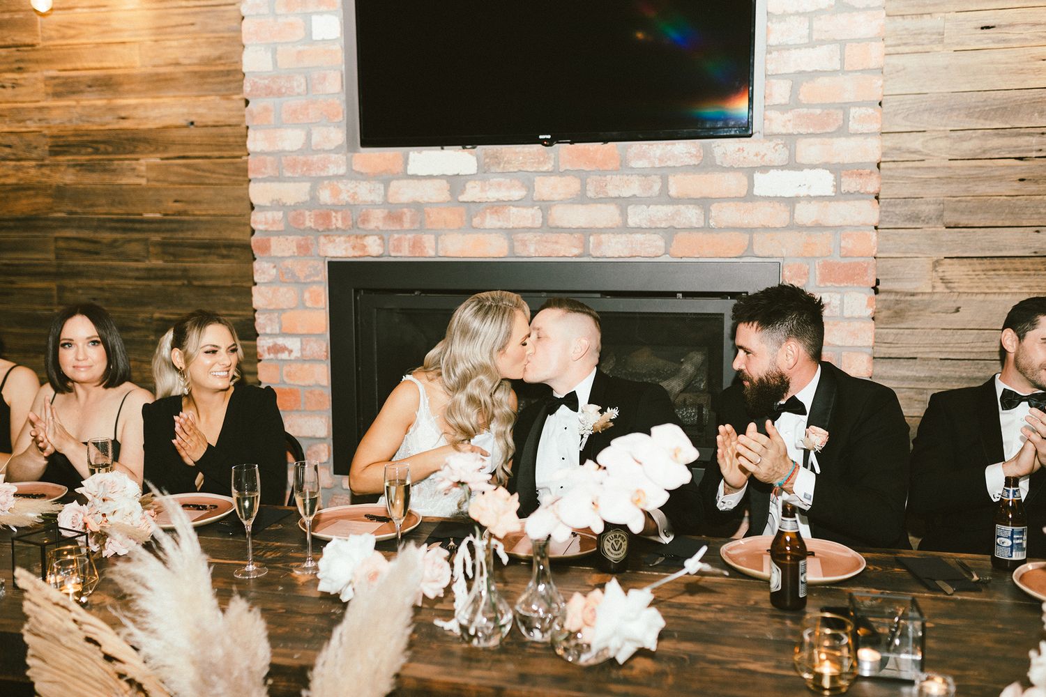 Guests enjoying a celebration at a rustic venue with exposed brick walls and elegant table settings.