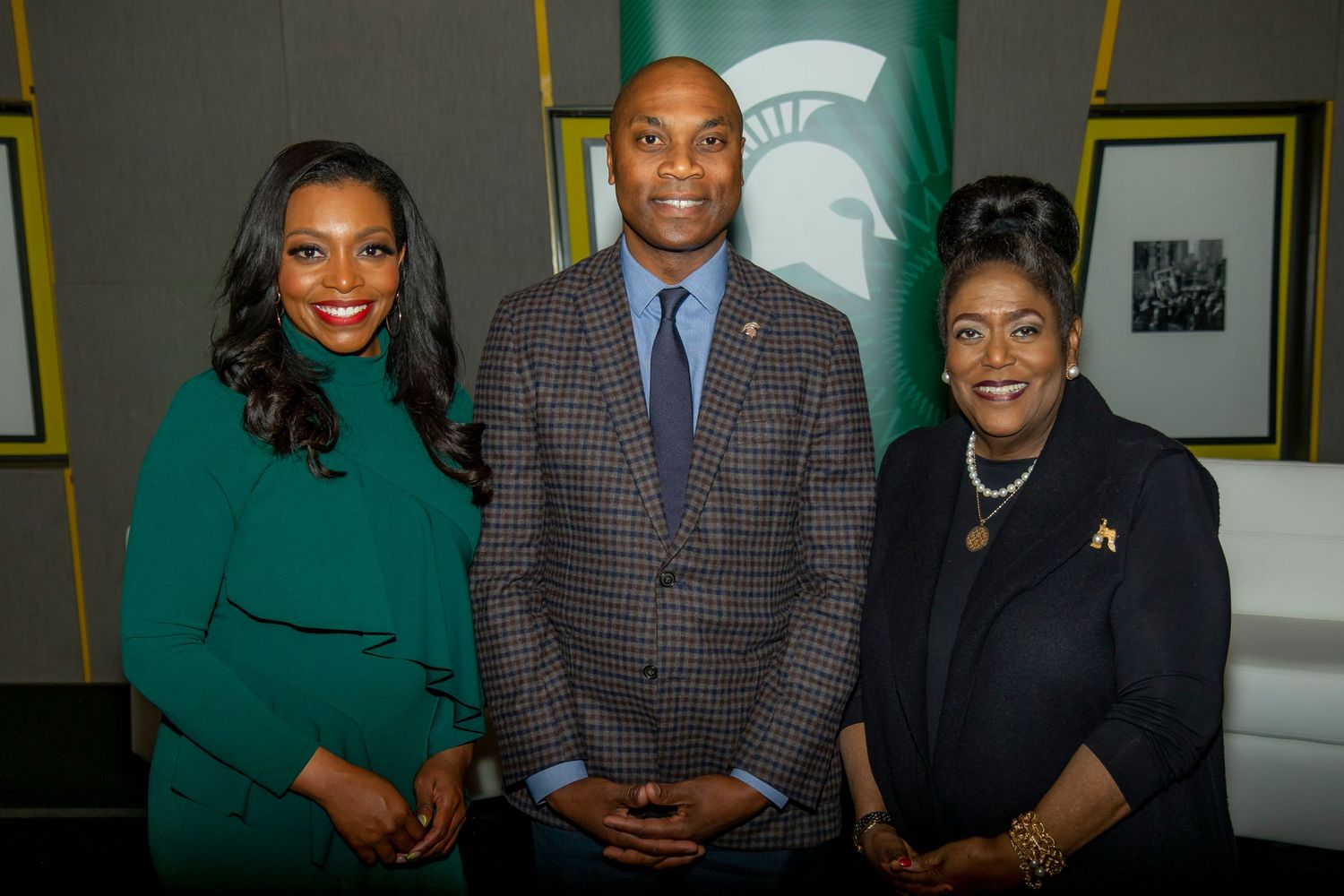 Three professionals pose together in an office setting with a Michigan State logo visible in the background.