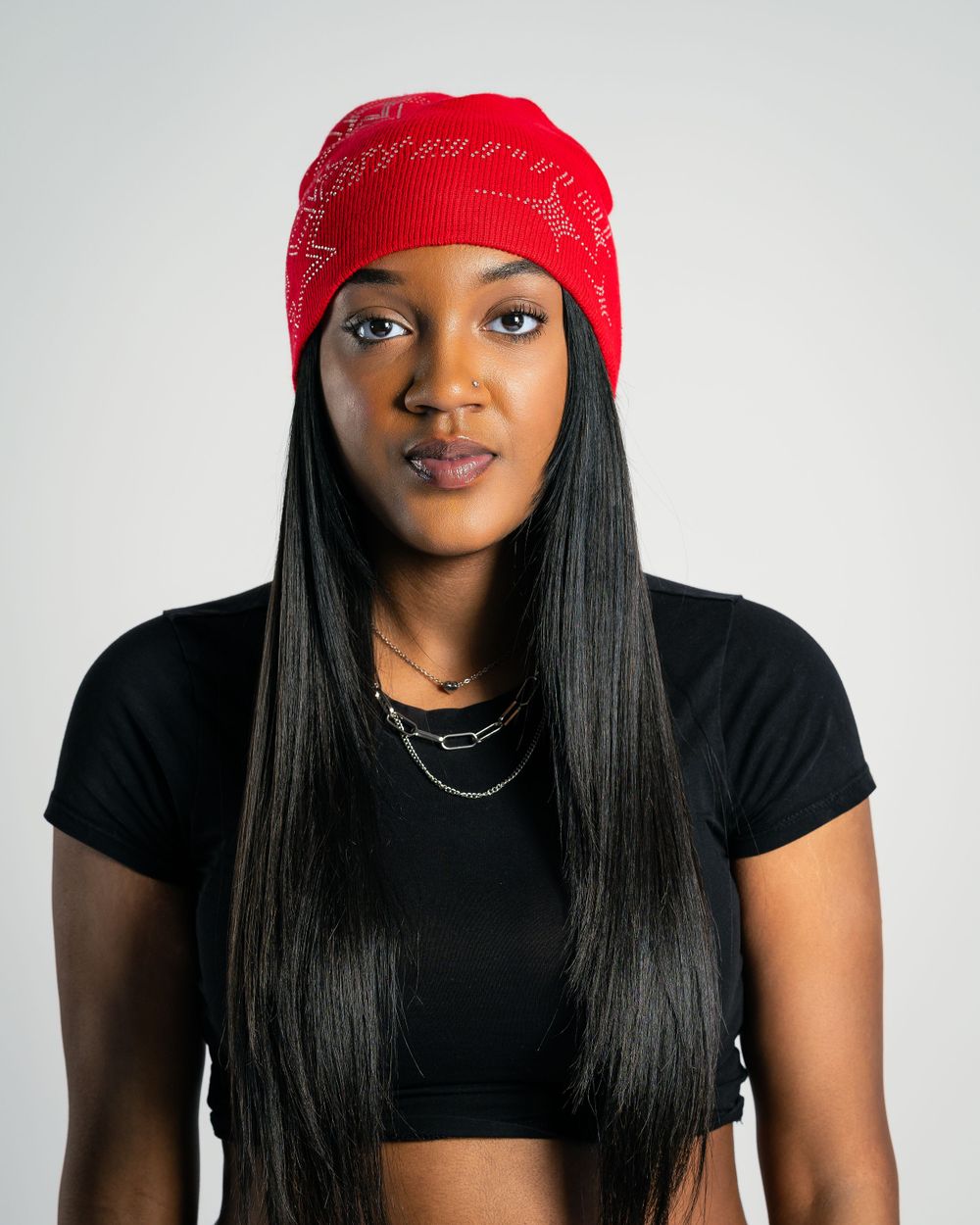 Studio portrait of model facing camera in red beanie — product fashion by Timoy B Photography.