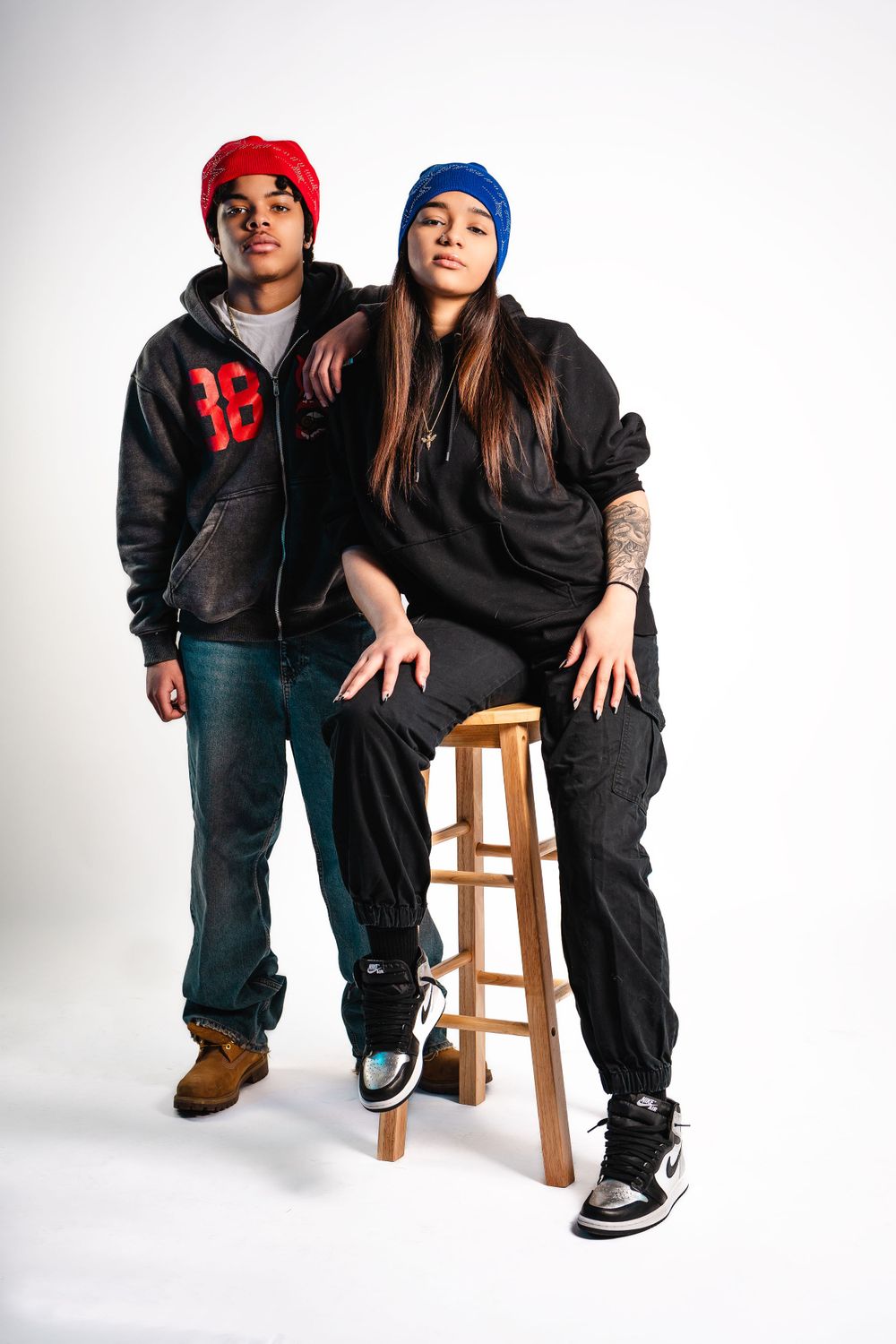 Duo portrait of models in casual streetwear and beanies — modern studio session by Timoy B Photography.