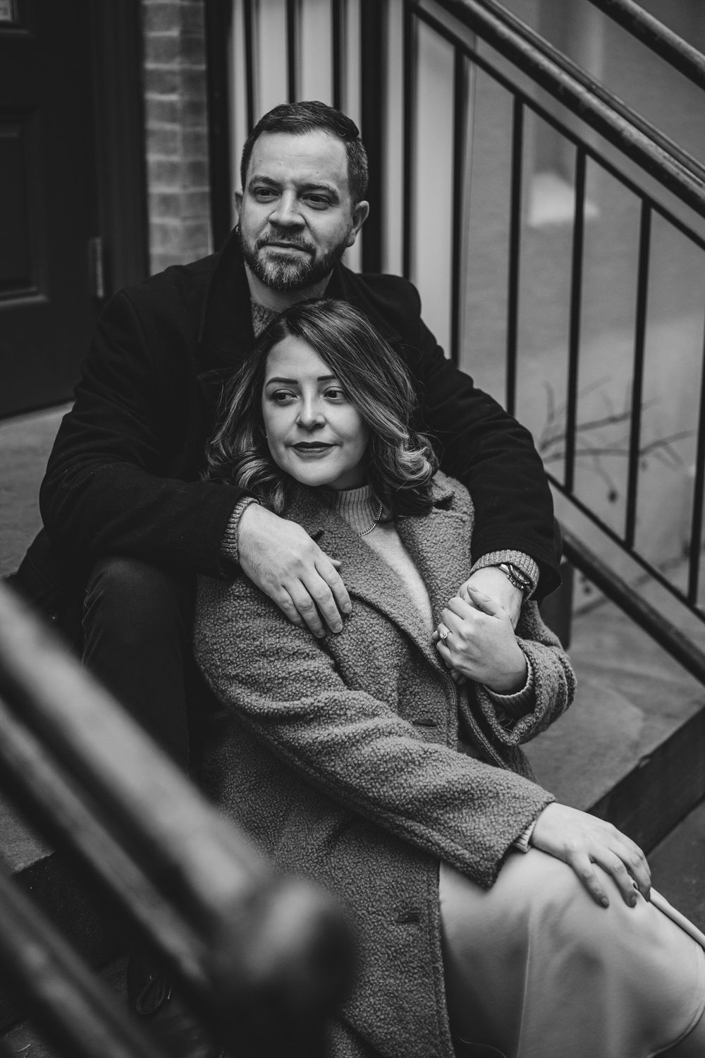 A black and white intimate portrait on outdoor steps.
