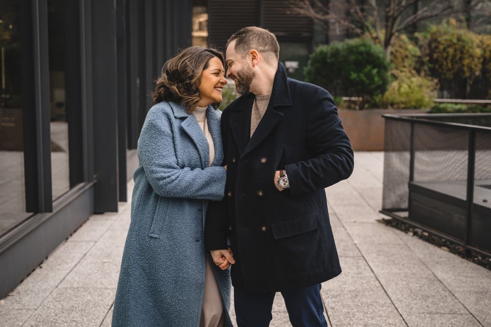 A romantic couple embraces while walking along an outdoor pathway.