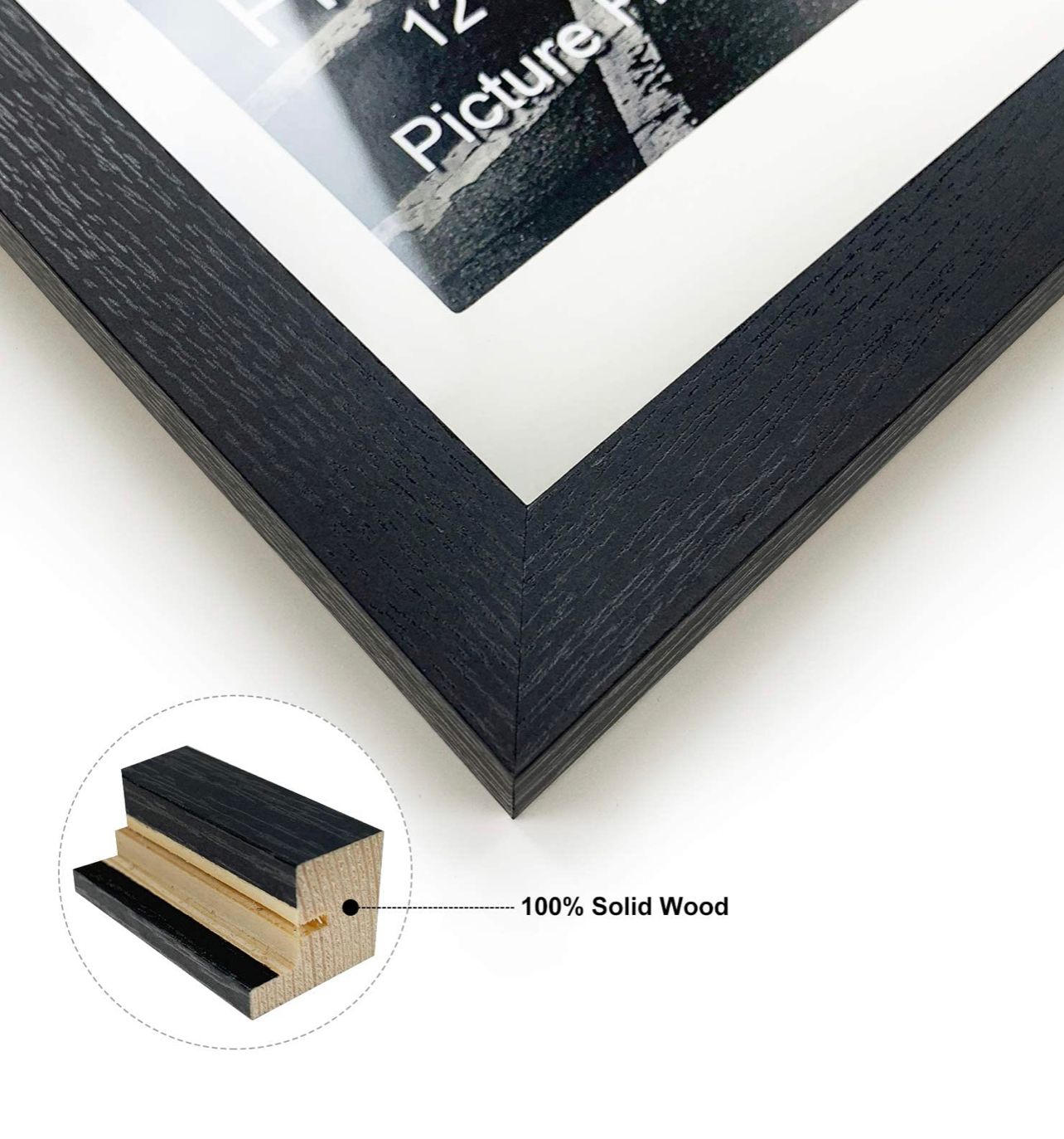 Close-up of a black solid wood picture frame corner with white mat, labeled 100% Solid Wood.