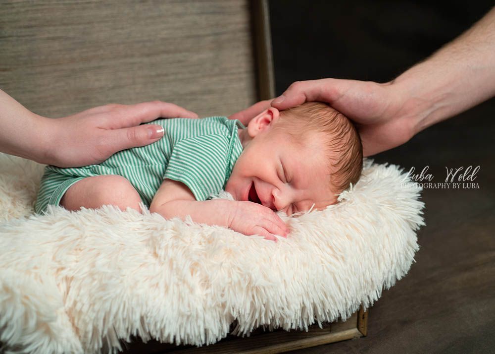newborn family photographer luba wold spokane baby boy smiling parents hands