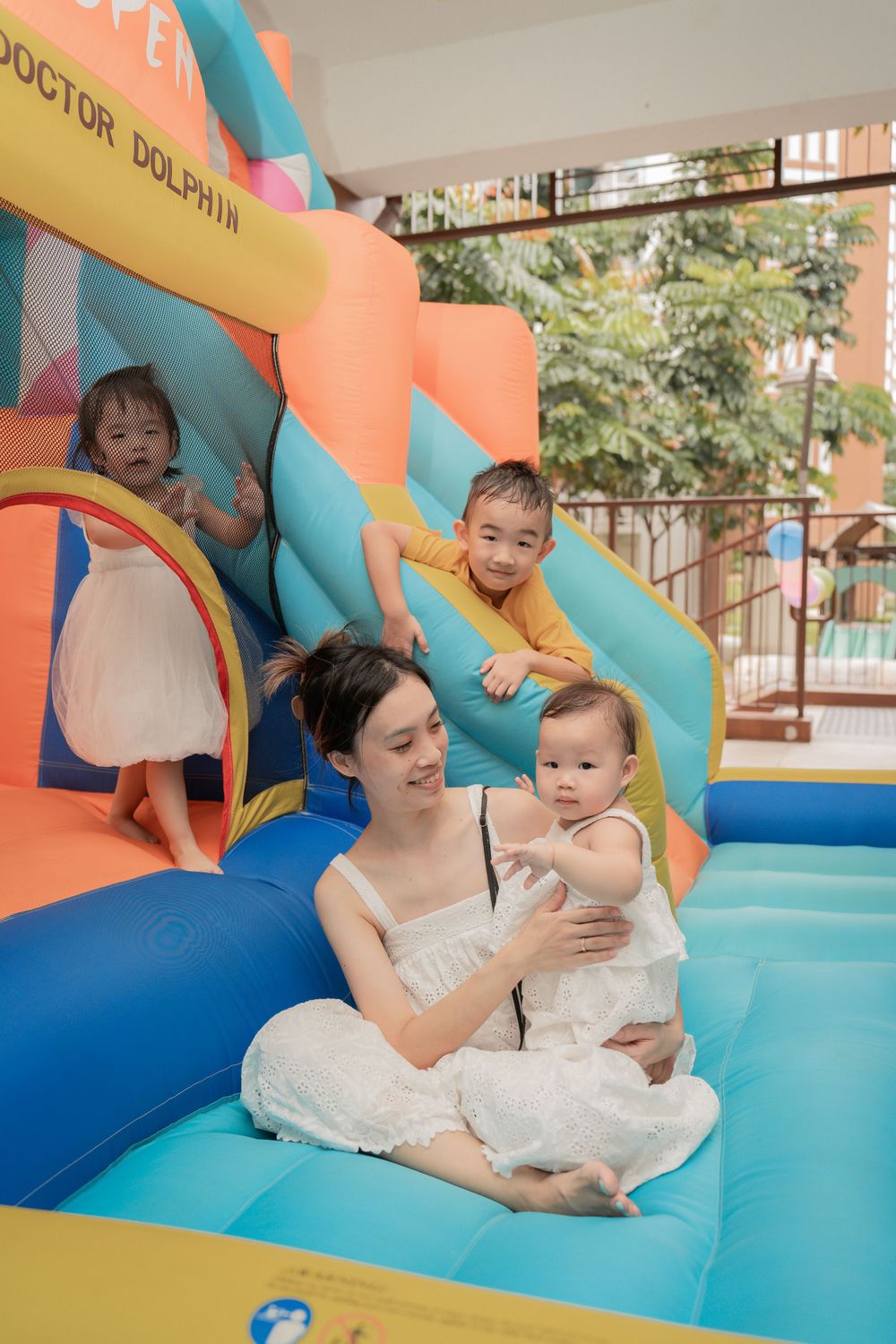 Children playing on a colorful inflatable bouncy castle with Doctor Dolphin branding.