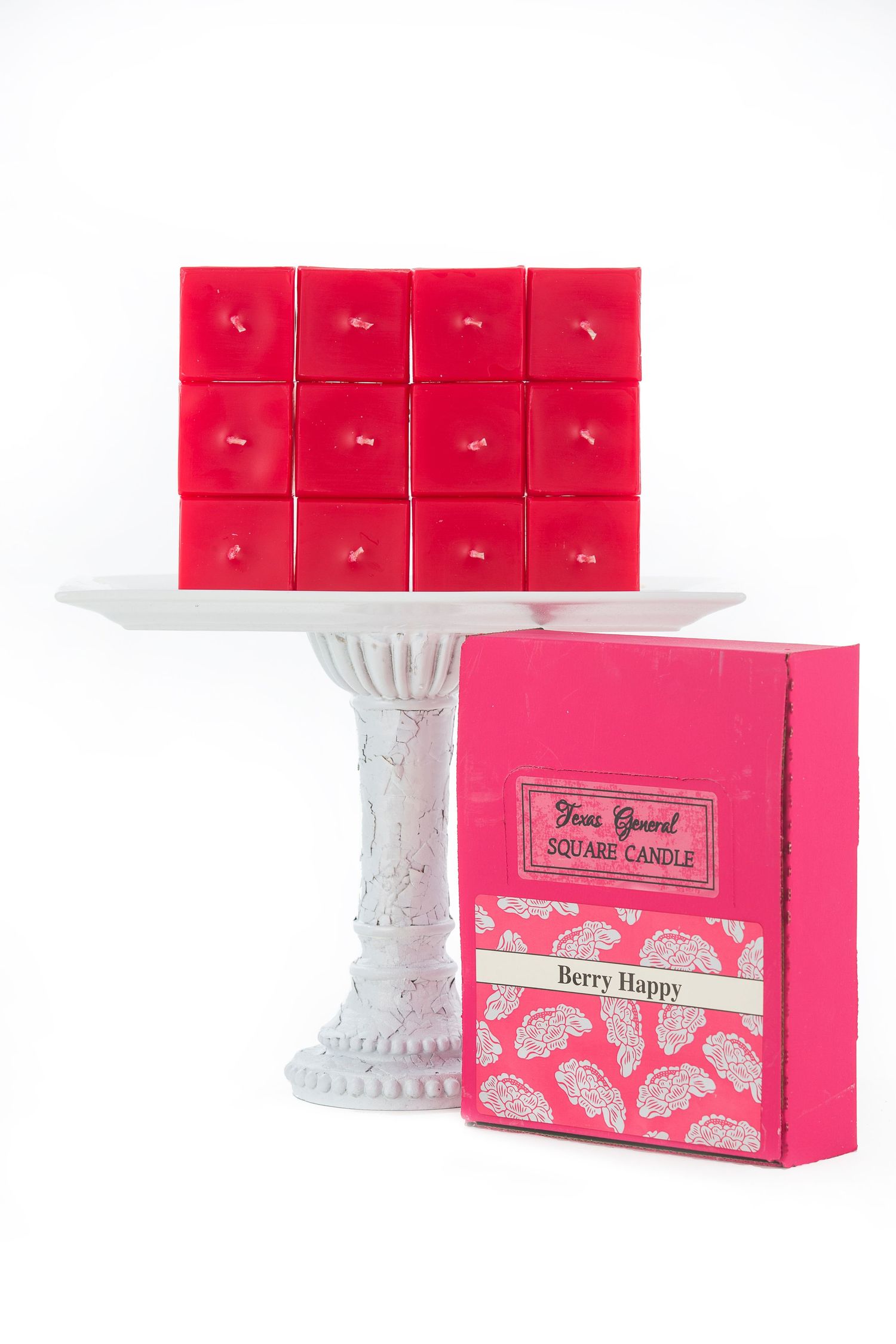 Hot pink scented wax melts arranged on a white pedestal stand with berry-themed packaging.