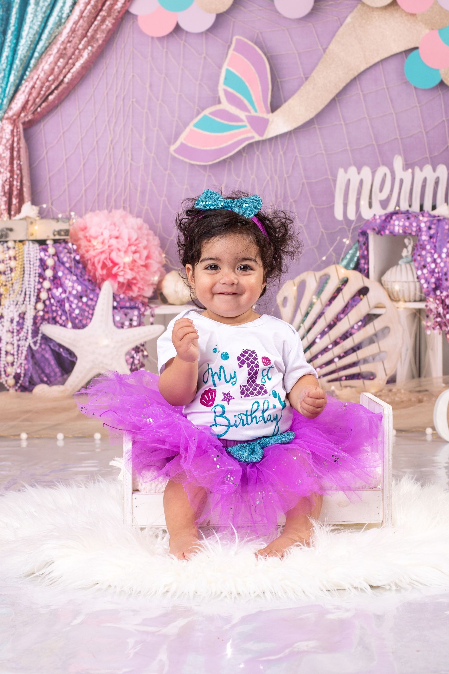 Mermaid themed birthday photo session with sparkly backdrop and purple tutu outfit.