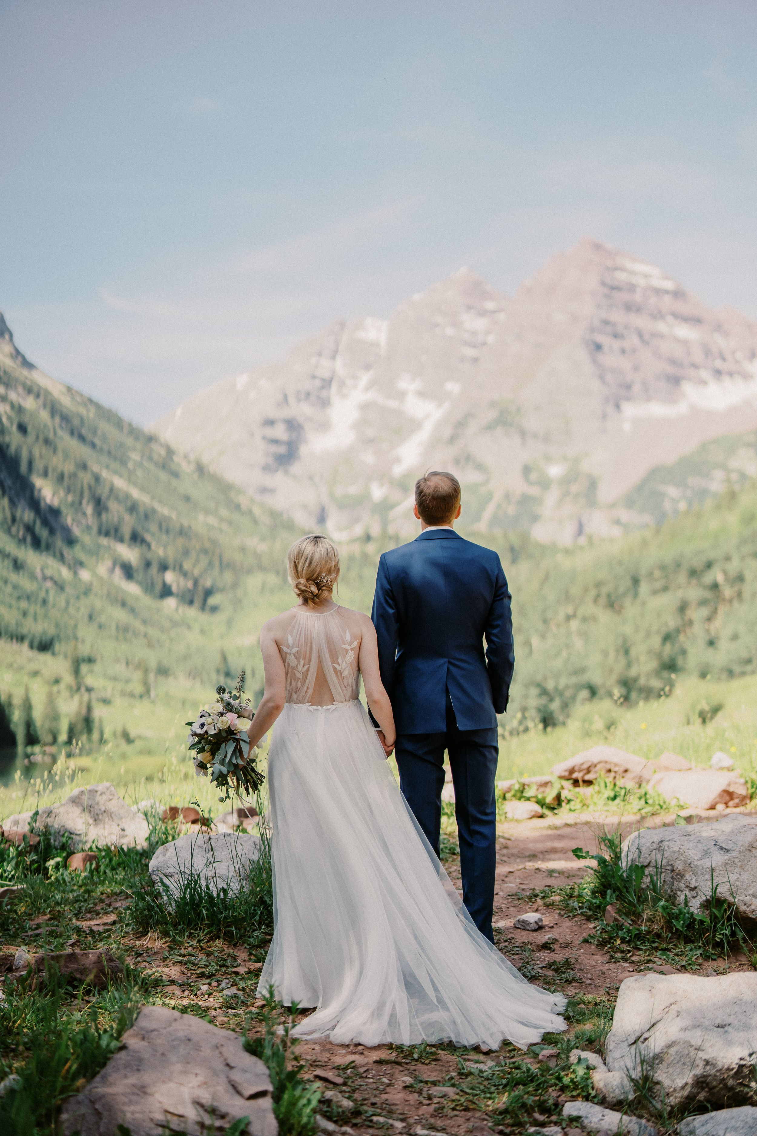 Couple admiring majestic mountain views in formal wedding attire at Maroon Bells.