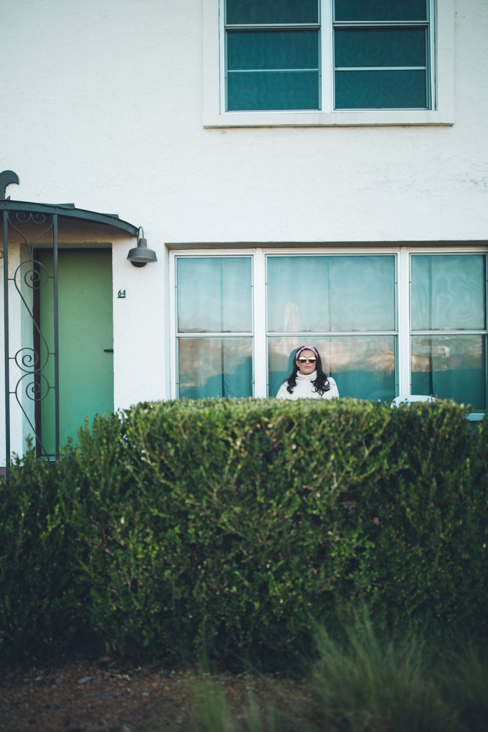 retro image of a Belmont hotel, Dallas, TX, teal, cream, green. woman in sunglasses, vintage headband framed in window