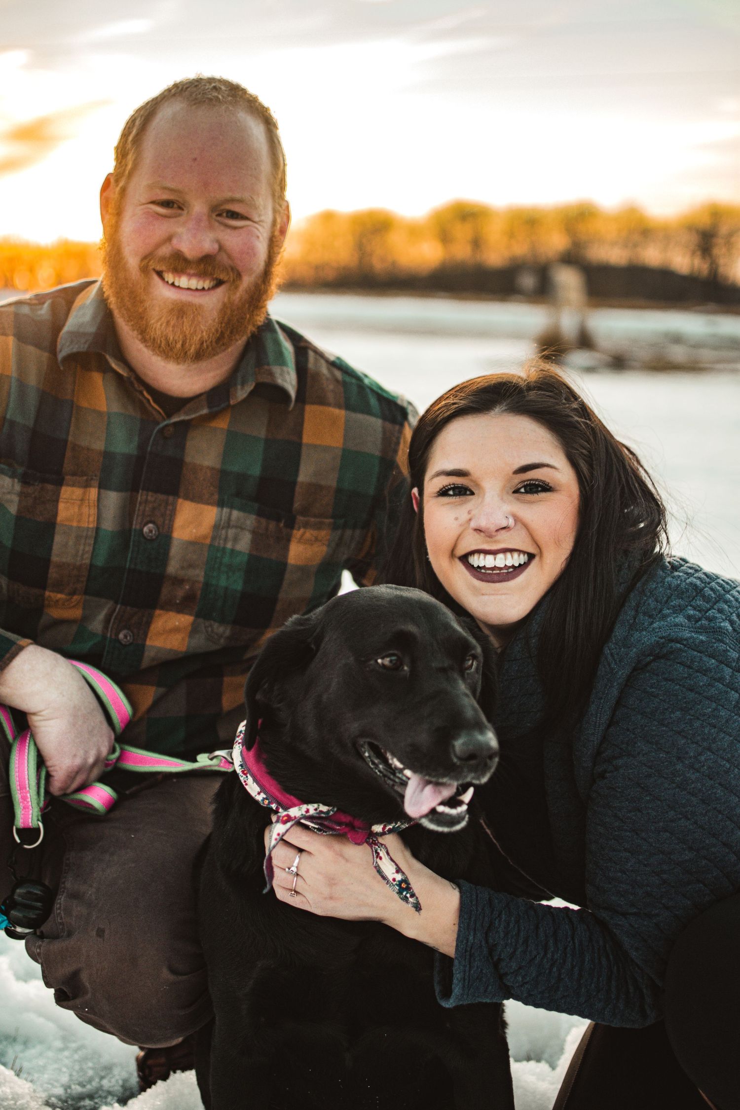 Happy outdoor portrait with black dog wearing pink bandana at sunset.