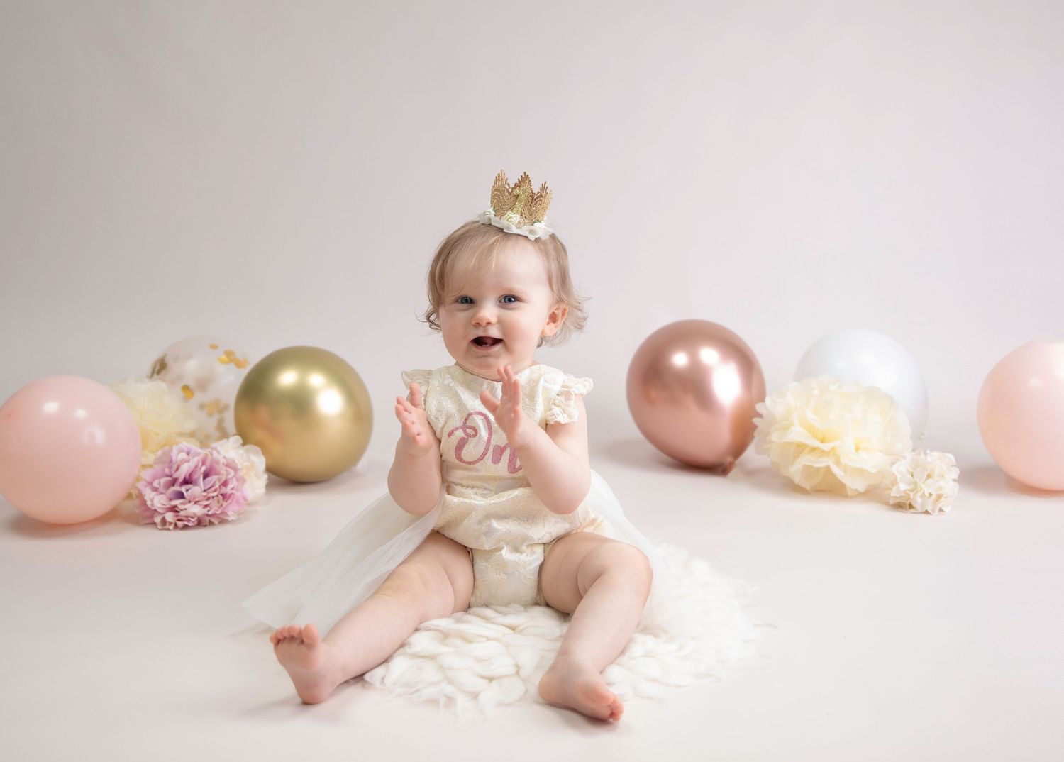 1st birthday sitter session, little girl wearing cream one dress, gold crown, cream, rose gold, pink, gold accessories